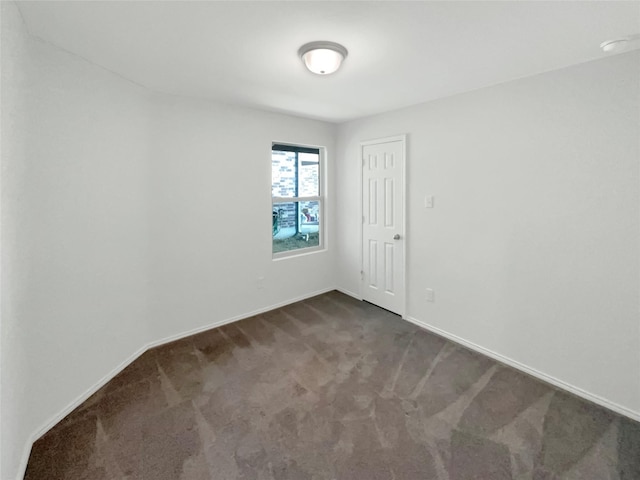 spare room with dark colored carpet