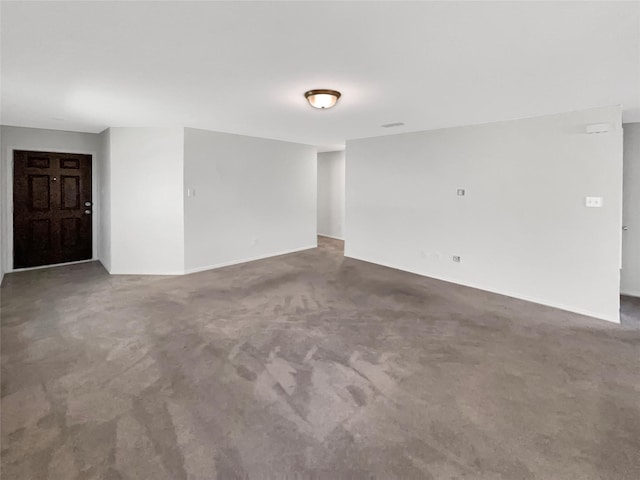 spare room with dark colored carpet