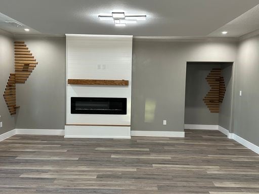 unfurnished living room featuring a fireplace and dark wood-type flooring