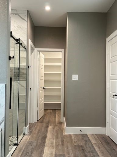 bathroom featuring hardwood / wood-style floors and a shower with door