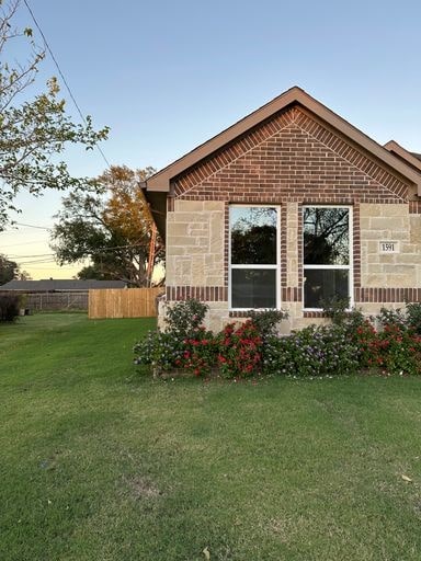 property exterior at dusk with a yard