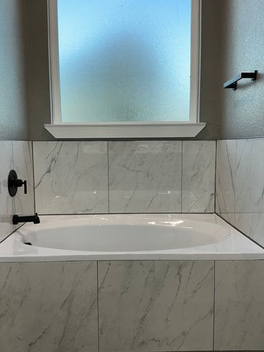 bathroom with a relaxing tiled tub