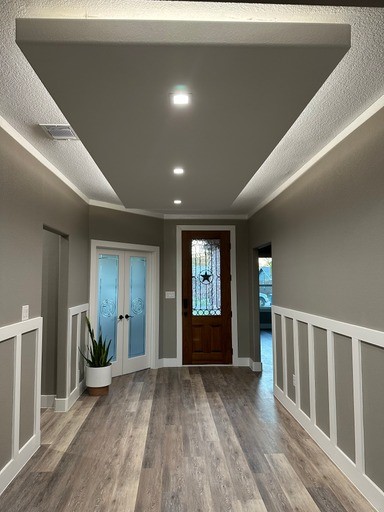 entryway featuring french doors, crown molding, and hardwood / wood-style floors