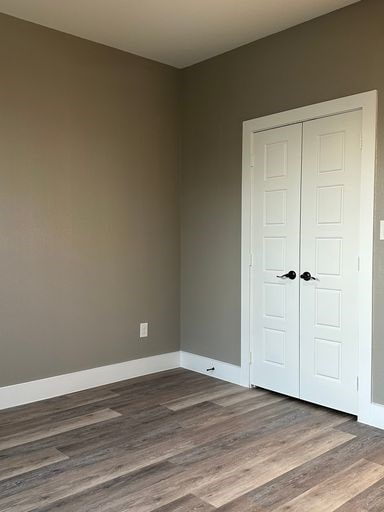 unfurnished bedroom featuring hardwood / wood-style floors and a closet