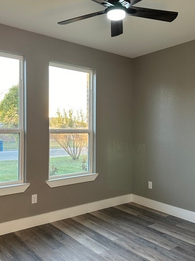 spare room featuring dark hardwood / wood-style flooring, plenty of natural light, and ceiling fan