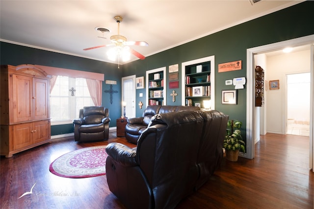 living room with built in shelves, dark hardwood / wood-style flooring, ceiling fan, and ornamental molding