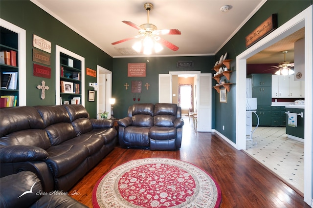 living room featuring hardwood / wood-style flooring, built in features, ceiling fan, and ornamental molding