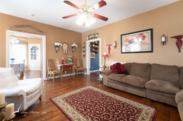 living room with ceiling fan and dark wood-type flooring