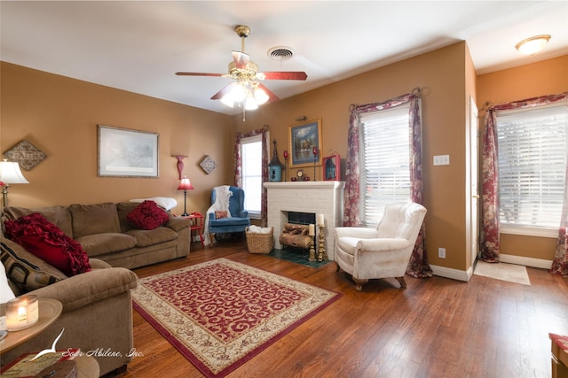 living room featuring a brick fireplace, ceiling fan, plenty of natural light, and hardwood / wood-style flooring