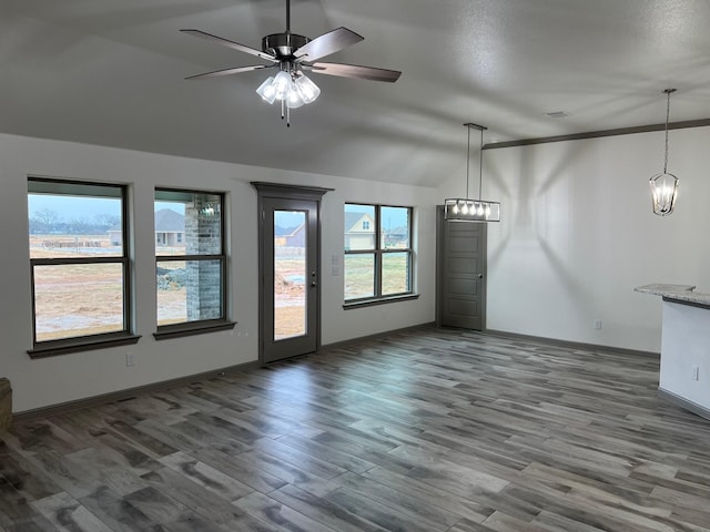 unfurnished living room with ceiling fan with notable chandelier, dark hardwood / wood-style flooring, and lofted ceiling