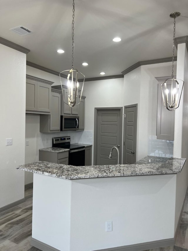 kitchen with kitchen peninsula, stainless steel appliances, and gray cabinetry