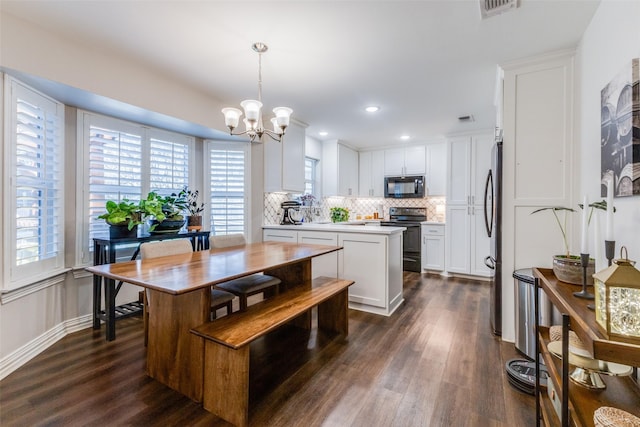 kitchen featuring hanging light fixtures, appliances with stainless steel finishes, a center island, and white cabinets