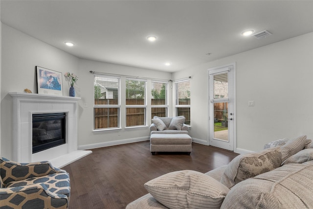 living room featuring dark hardwood / wood-style flooring and a tile fireplace