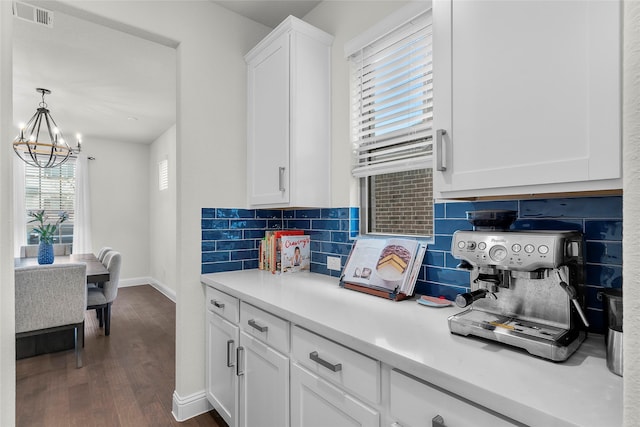 kitchen featuring decorative light fixtures, decorative backsplash, white cabinetry, dark hardwood / wood-style flooring, and a chandelier