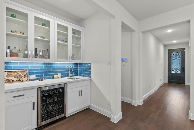 bar featuring decorative backsplash, sink, white cabinets, dark hardwood / wood-style flooring, and beverage cooler