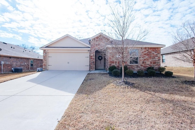 ranch-style house featuring an attached garage, central air condition unit, concrete driveway, and brick siding