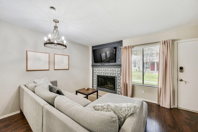 living room with a fireplace, dark hardwood / wood-style floors, and a chandelier