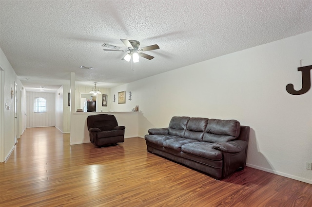 living room with ceiling fan, hardwood / wood-style floors, and a textured ceiling