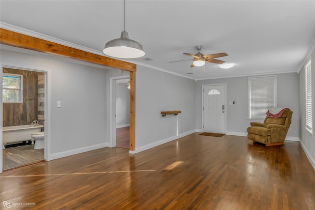 foyer with crown molding, dark wood-type flooring, and ceiling fan