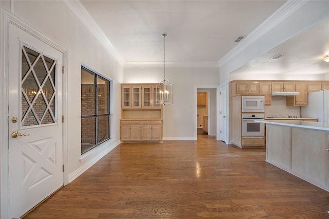 kitchen with light brown cabinetry, hanging light fixtures, light hardwood / wood-style flooring, ornamental molding, and white appliances