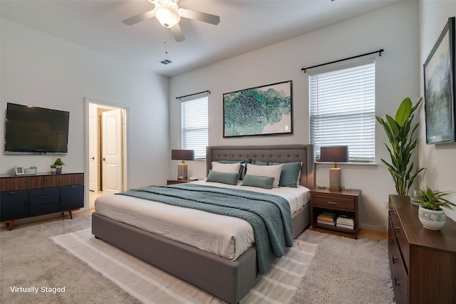 bedroom with ceiling fan, ensuite bathroom, and multiple windows