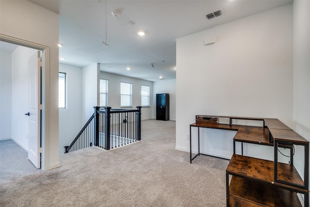 hallway featuring a wealth of natural light and carpet flooring