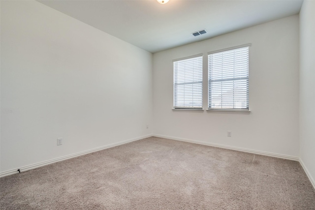 spare room featuring light colored carpet