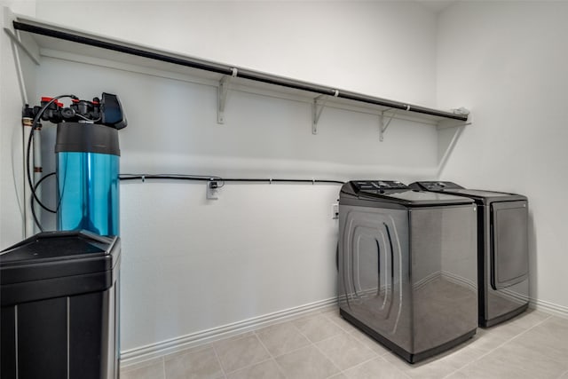 laundry room featuring washing machine and dryer and light tile patterned floors