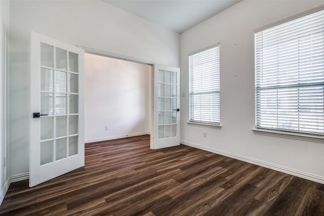 unfurnished room featuring plenty of natural light, dark hardwood / wood-style flooring, and french doors