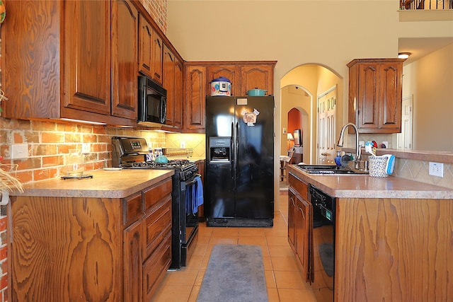 kitchen with sink, light tile patterned floors, decorative backsplash, and black appliances