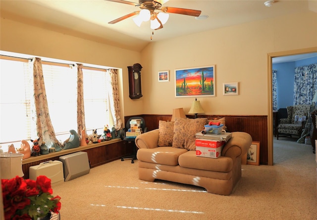 living room with ceiling fan, light colored carpet, and wooden walls