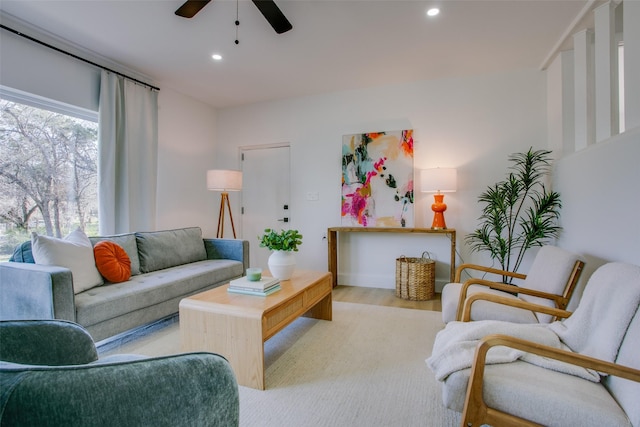 living room with light hardwood / wood-style flooring and ceiling fan