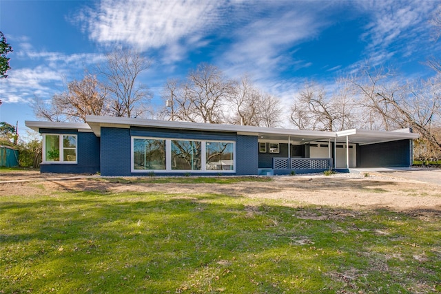 rear view of property with a yard and a carport