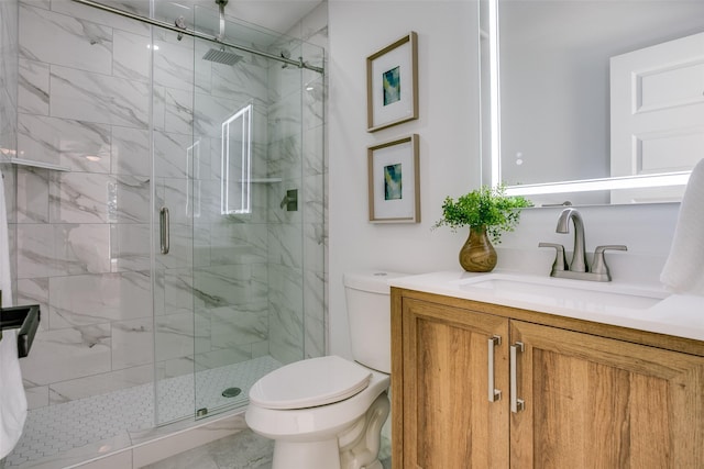 bathroom featuring vanity, toilet, and a shower with door