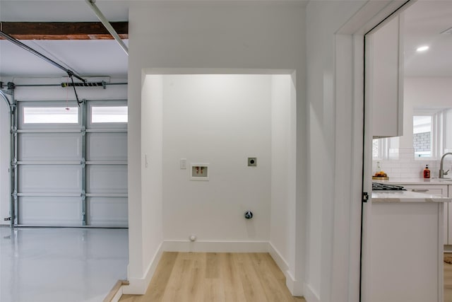 laundry room featuring washer hookup, electric dryer hookup, and light wood-type flooring