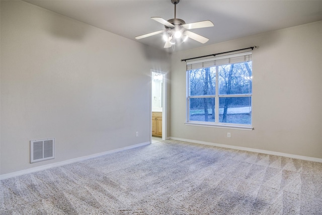 carpeted spare room featuring ceiling fan