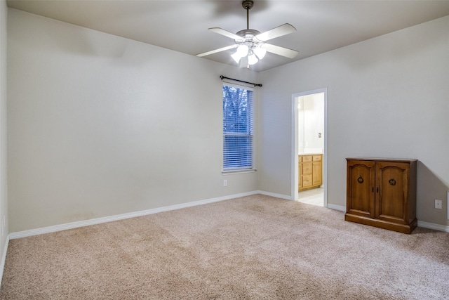 spare room with ceiling fan and light colored carpet