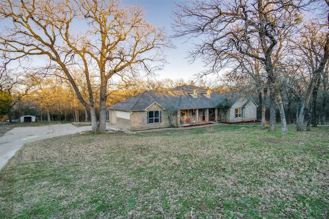 ranch-style house with covered porch and a yard