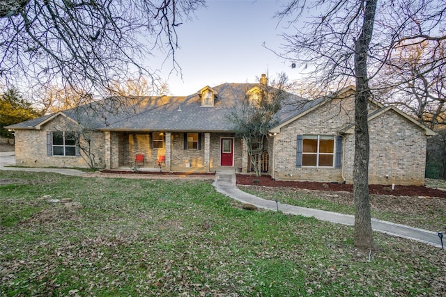 single story home featuring covered porch and a front lawn