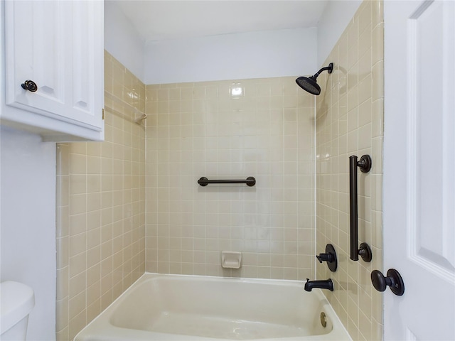 bathroom with toilet and tiled shower / bath combo