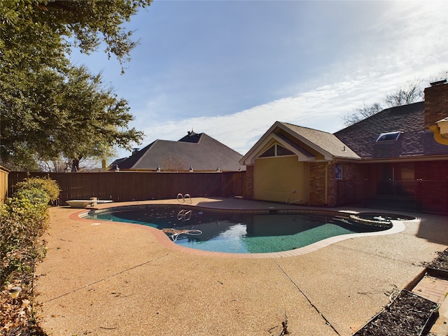 view of swimming pool featuring a diving board, a patio, and an in ground hot tub