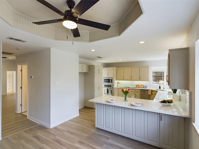 kitchen with sink, light hardwood / wood-style flooring, kitchen peninsula, and appliances with stainless steel finishes