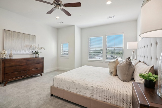 carpeted bedroom with multiple windows and ceiling fan