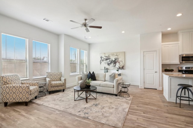 living room with ceiling fan and light wood-type flooring