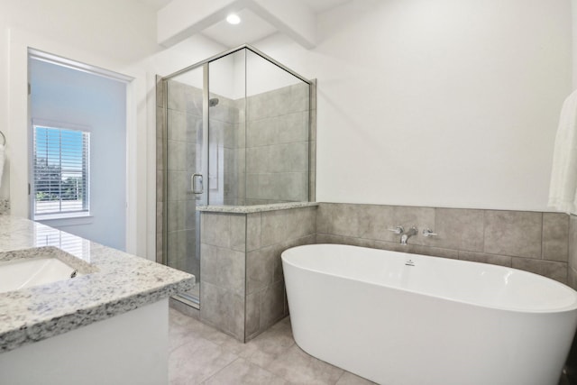 bathroom featuring tile patterned floors, vanity, shower with separate bathtub, and tile walls