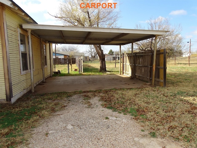 exterior space with a carport and a lawn