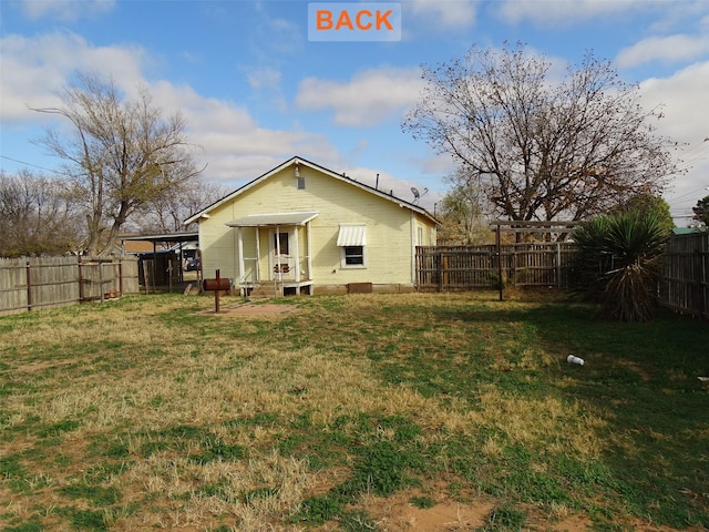 rear view of property with a yard