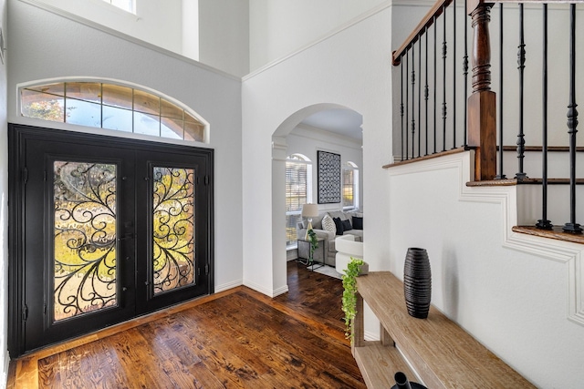 entrance foyer with dark hardwood / wood-style flooring, ornamental molding, and french doors