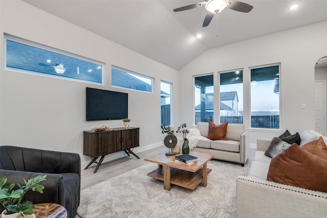 living room featuring ceiling fan, lofted ceiling, and light wood-type flooring