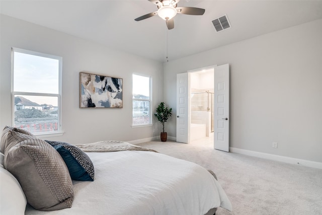 carpeted bedroom featuring ceiling fan and ensuite bath